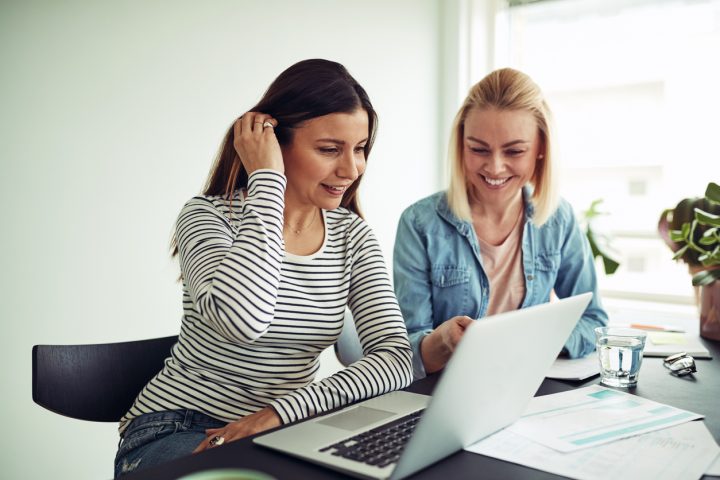 Två kvinnor tittar på en dator