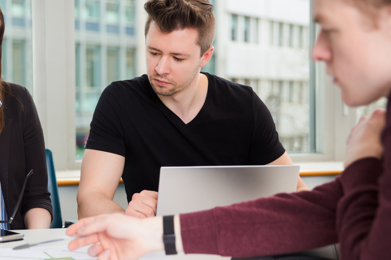 Grupp människor sitter och arbetar vid ett skrivbord