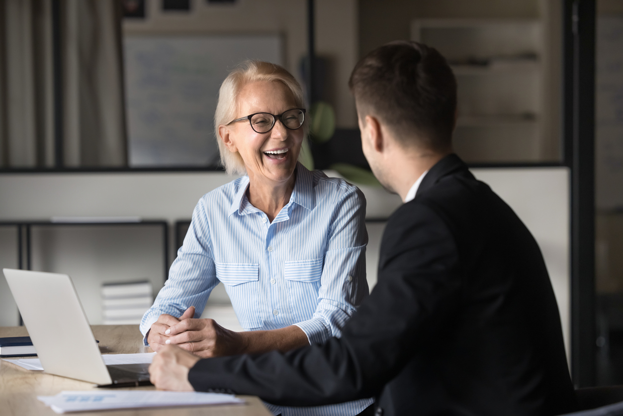 Man och leende kvinna pratar vid dator