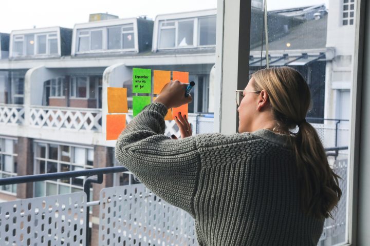 Kvinna sätter post-its på fönster